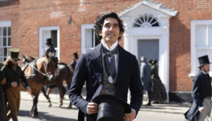 A smiling man walks in the street in Victorian England.