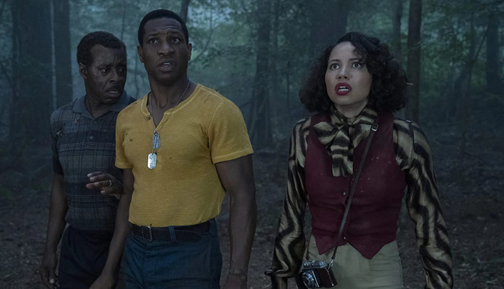 Three startled African-Americans in a forest.