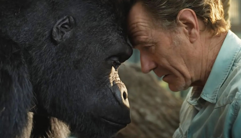 A man and a gorilla touch foreheads.