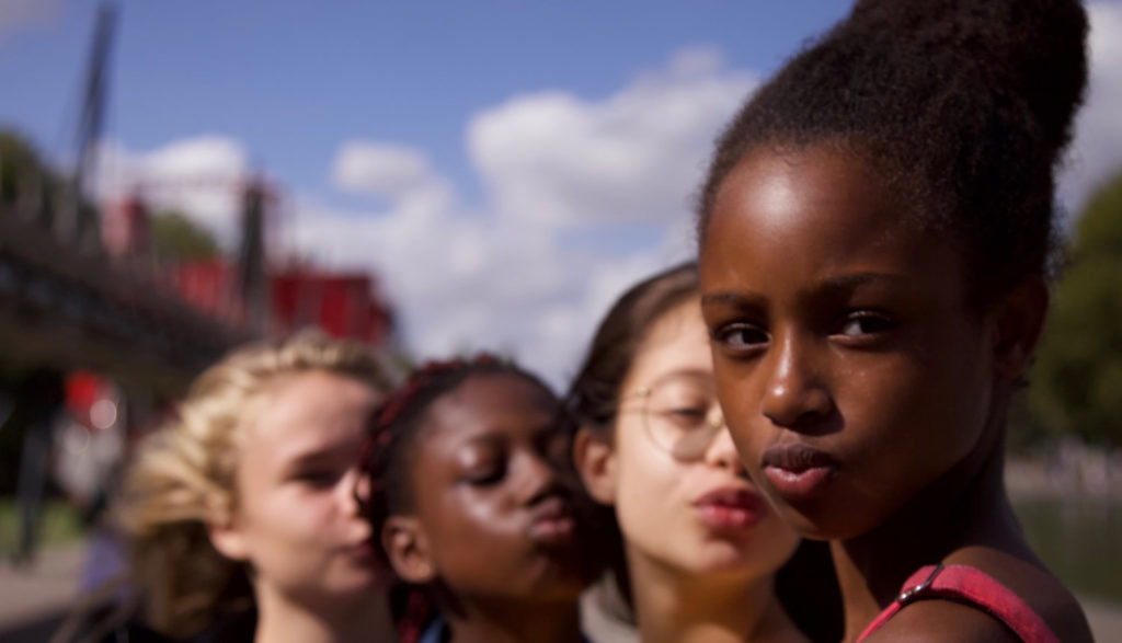 Four girls make pouting, selfie faces.