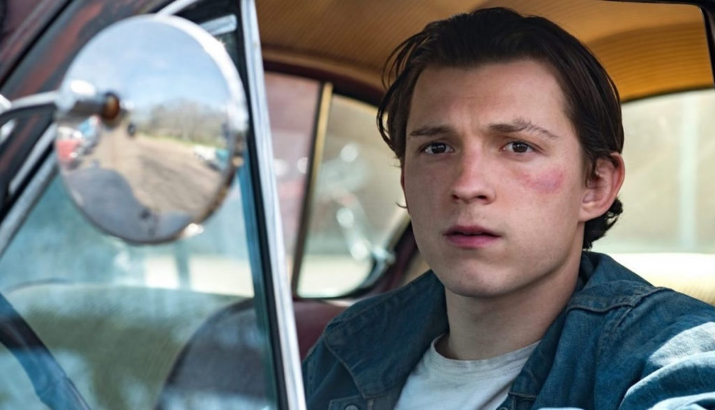 A young man with a bruise on his face looks out a truck window.