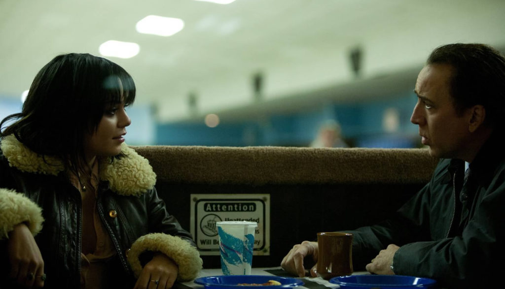 A man and a woman talk at a diner.