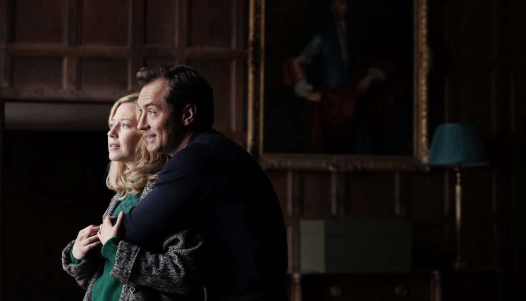 A husband hugs a wife in their new home.