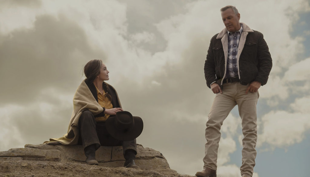Kevin Costner and Diane Lane are pictured as a farming couple talking to each other against the backdrop of clouds and sky.