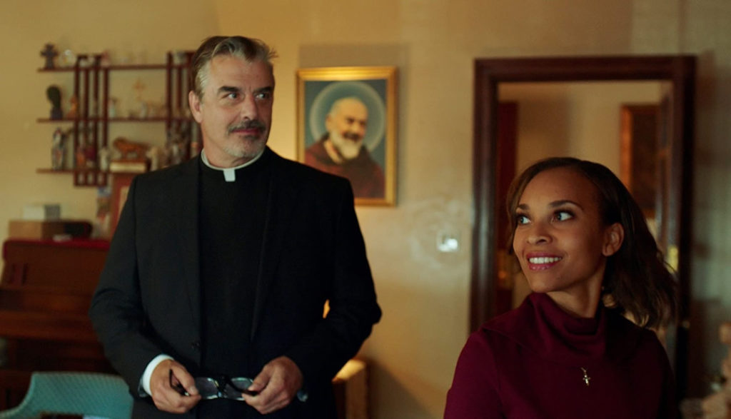 A woman smiles as she talks with her Catholic priest.