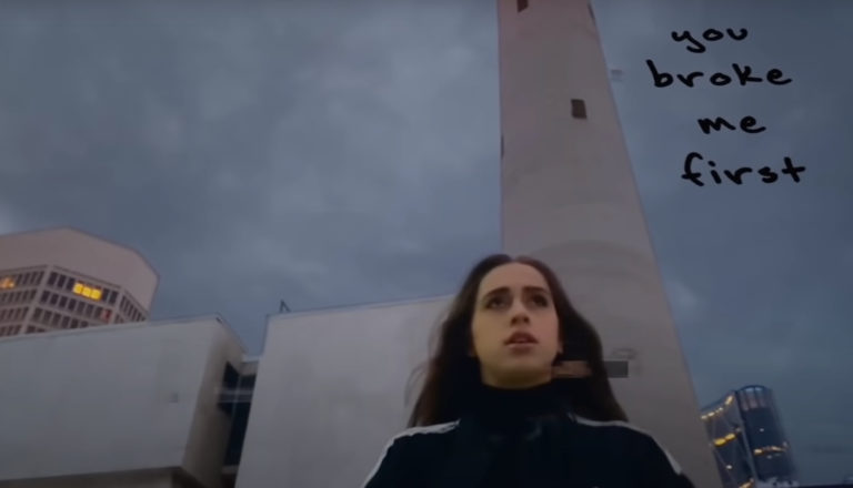 A young woman walks through a city.
