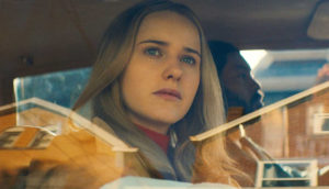 A woman looks out a car window.