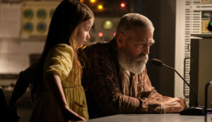 George Clooney and a young girl stare at something at a desk in The Midnight Sky.