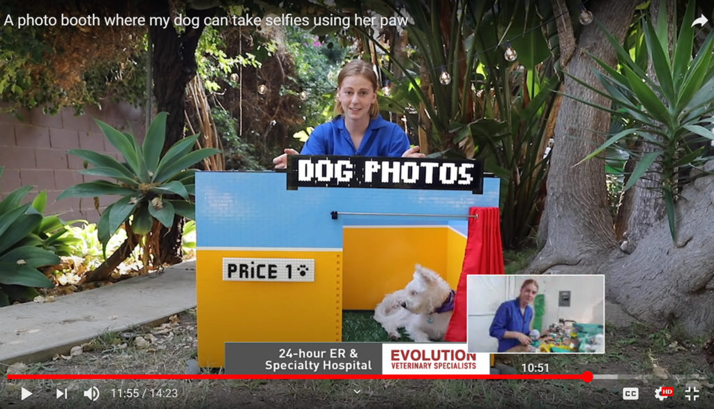 Simone Giertz posing with the selfie phone booth she made for her dog.