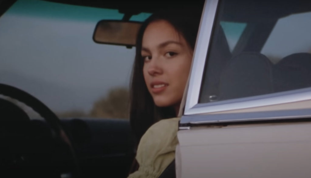 Singer Olivia Rodrigo looks out the car door in her video for "Driver's License."