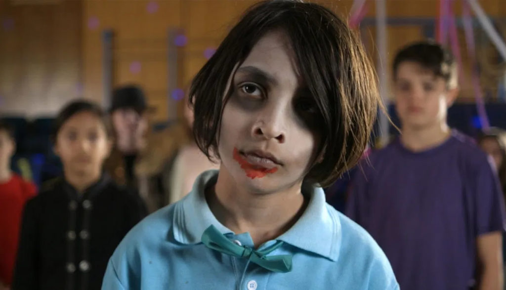 A tween zombie boy stares at the camera.