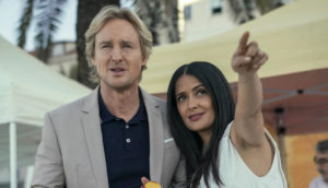 A man and a woman look at something she's pointing at.