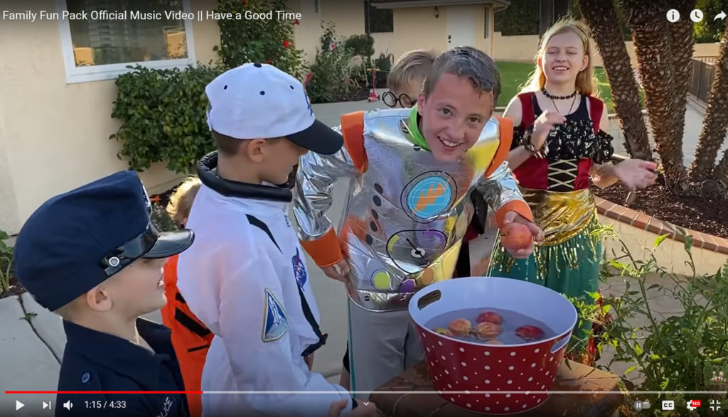 We see kids doing some kind of fun activity involving a huge bucket of water.