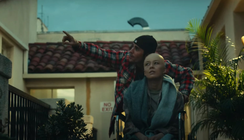 Justin Bieber plays a man whose wife is dying of cancer in this shot from the video for the song "Hold On." He's pushing her in a wheelchair here.