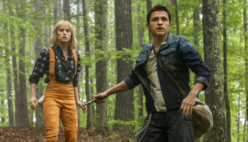 A concerned young man and woman walk through a forest.