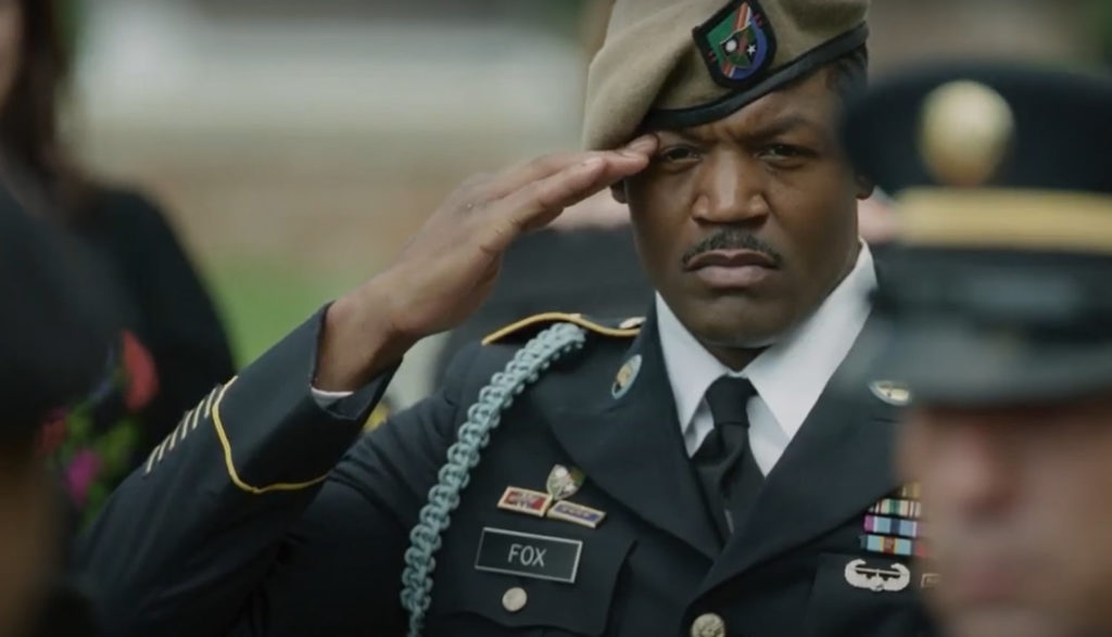 A soldier salutes during a funeral.