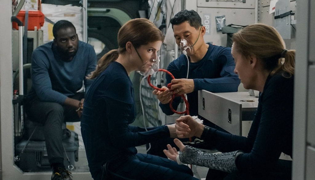 Four astronauts talk on their ship in the movie "Stowaway."