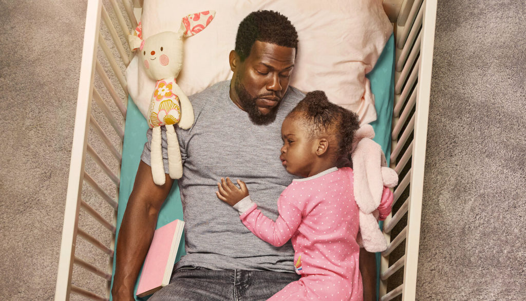 Father cradling his daughter in her crib in Fatherhood