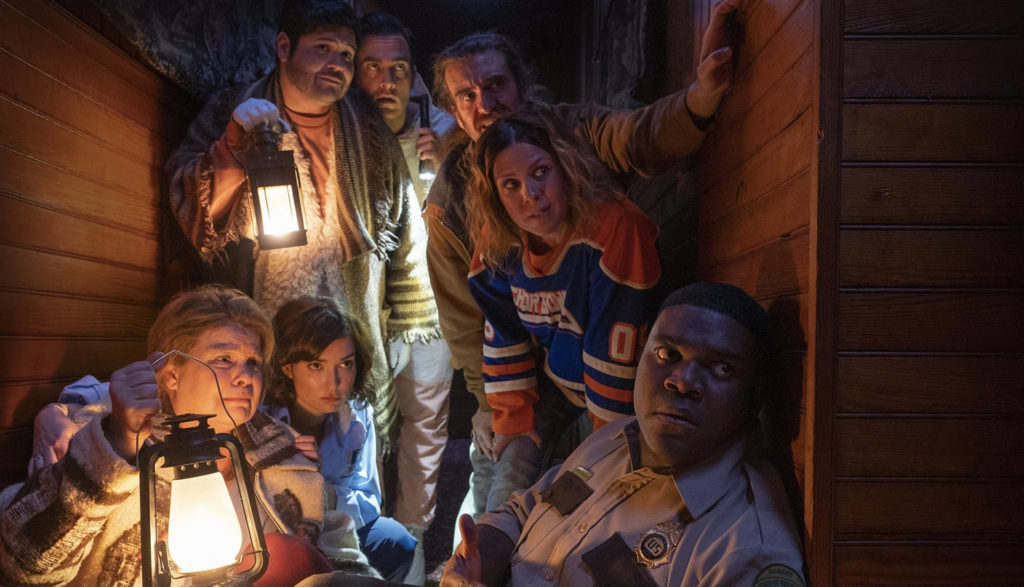 A group of people huddle together in a hallway.