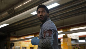 An injured man stands in a subway