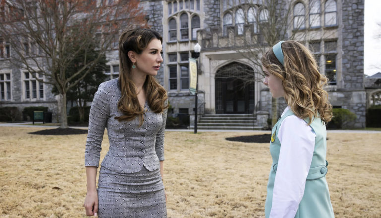 Two women talking in a yard.