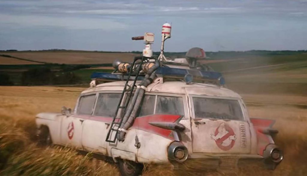 Ecto 1 driving through field in Ghostbusters Afterlife movie