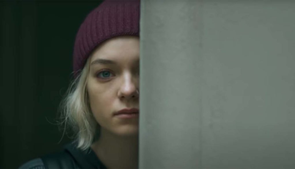 A girl peaking from behind a wall in Hanna tv series