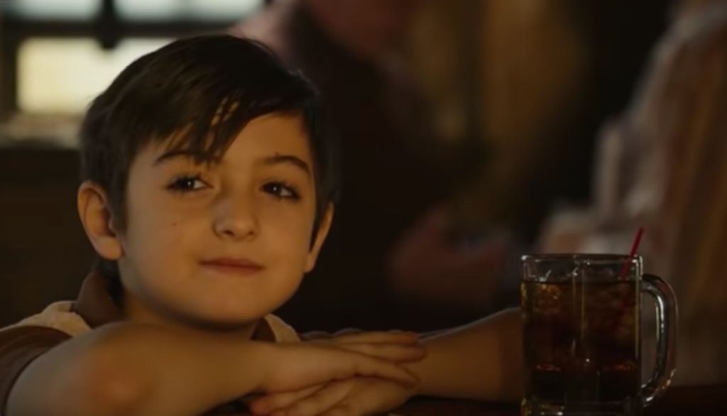 a boy with a soda at his parents' bar in The Tender Bar movie