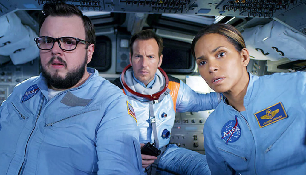 Three astronauts look out the windshield of their spacecraft with concern.