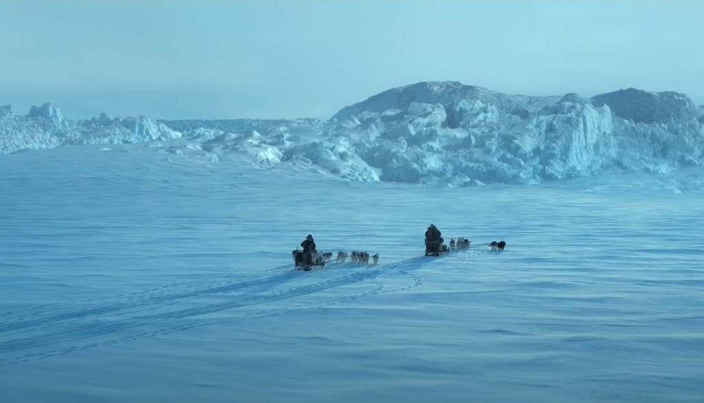 Two men pilot dogsleds across the artic wilderness.