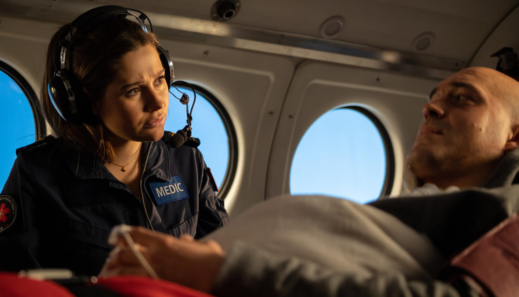 A female nurse helps a patient on a plane.