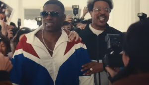 Mike Tyson and his entourage make their way through press and cameras.