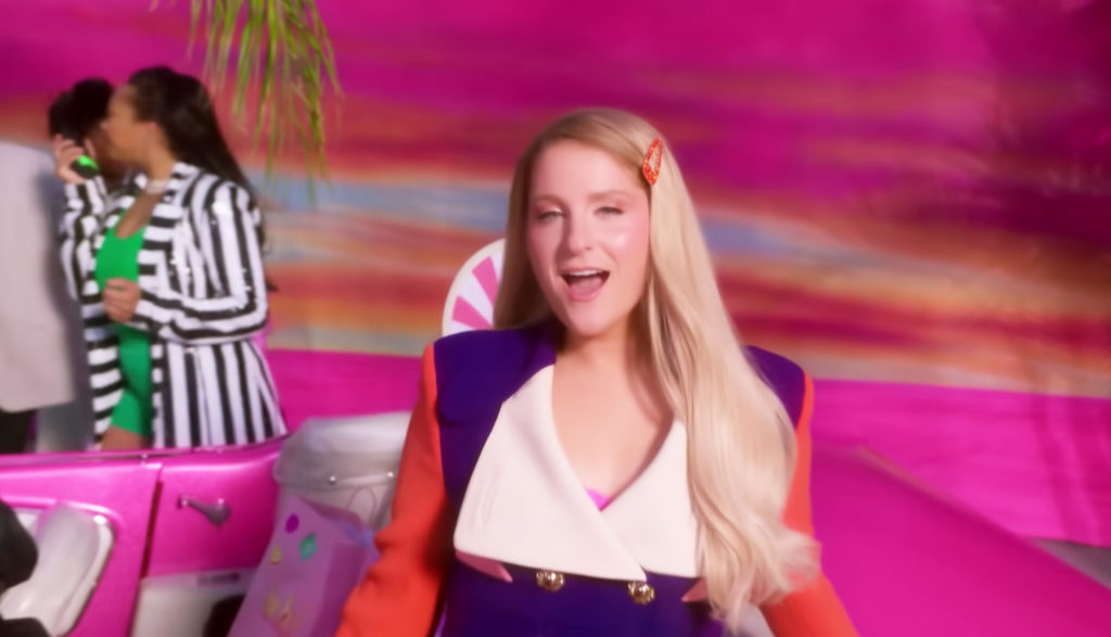 Meghan Trainor singing in front of pink background in "Made You Look" music video