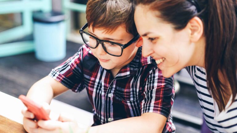 Mom looks on as child plays Pokemon Go