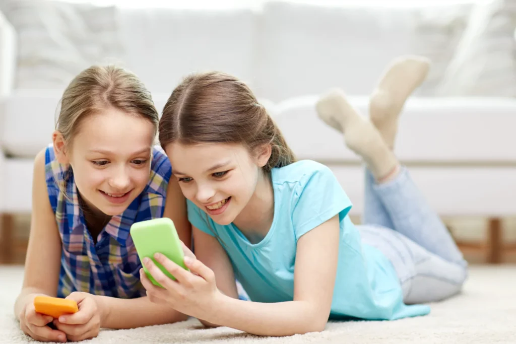 two young girls on their cell phones|phone time