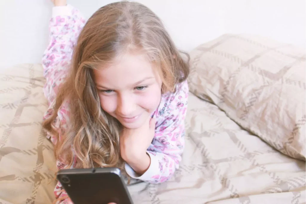 Tween girl on her bed texting teen slang