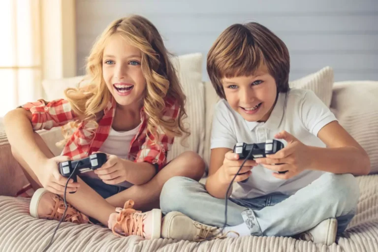 Young boy and girl sitting on a couch having fun playing video games